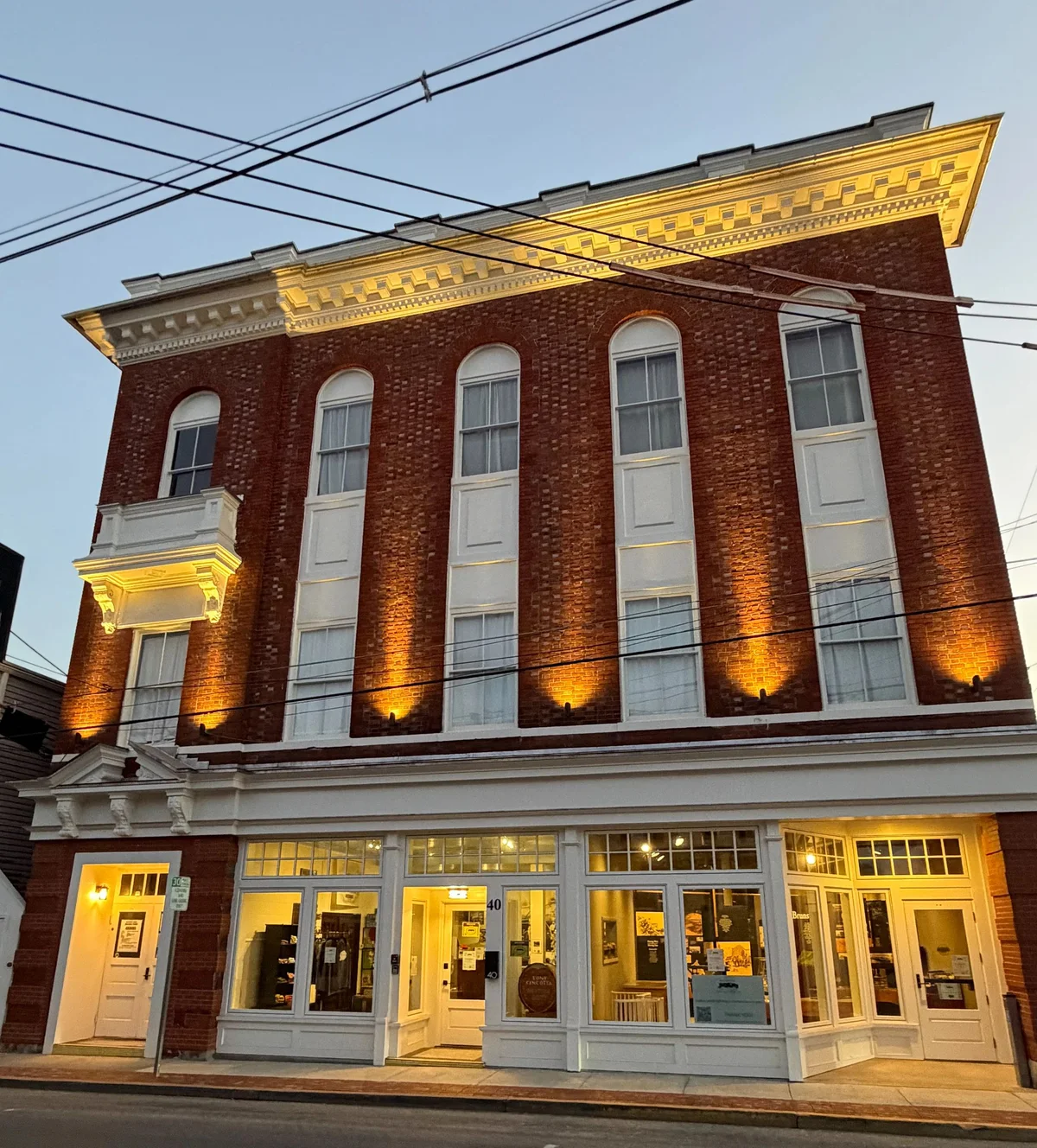 The museum’s three-story brick façade and illuminated entrance at dusk