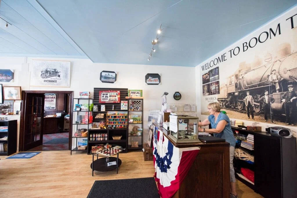 A volunteer welcomes visitors at the museum reception desk